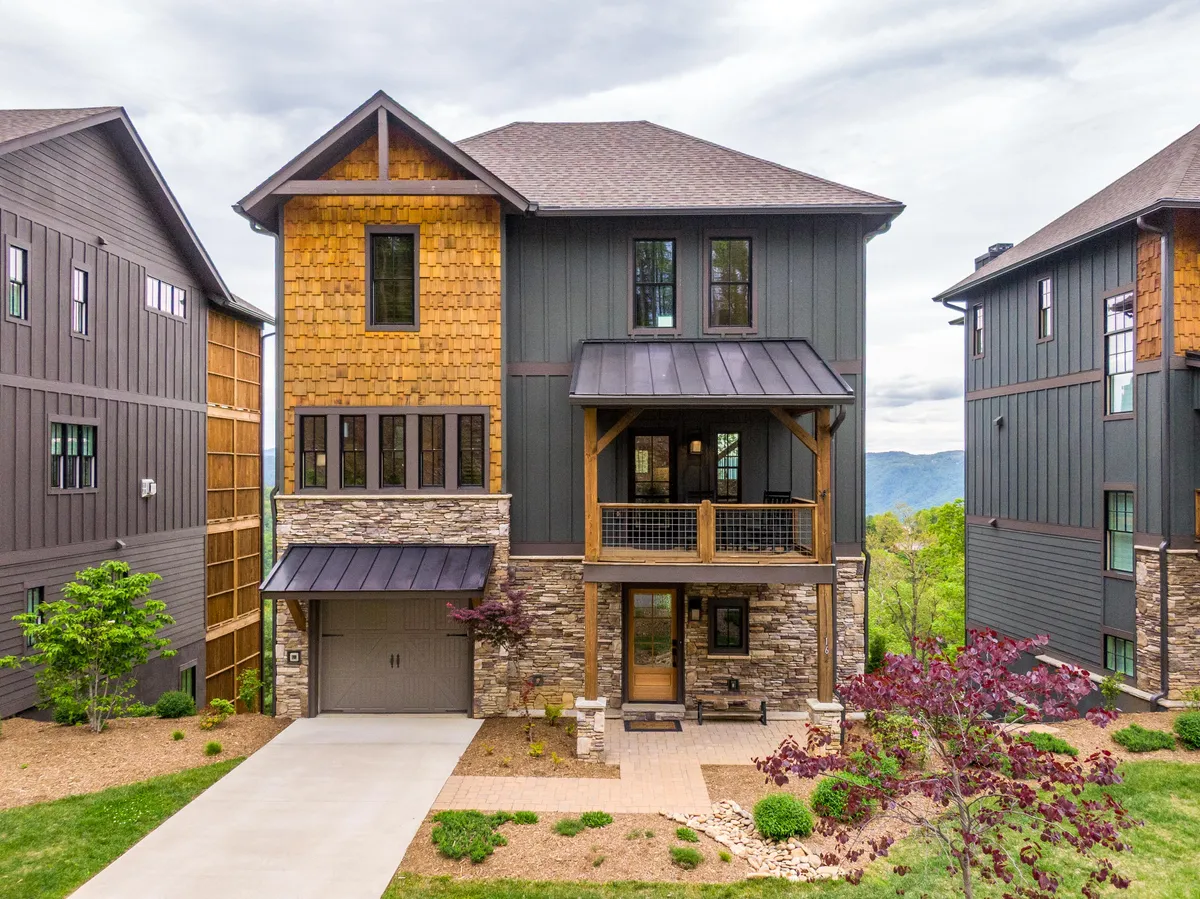 The hero image showcases the inviting stone facade and rustic wooden accents of North Face Cottage, with a welcoming front porch perfect for gathering. At sunset, the porch glows with warm light, hinting at breathtaking mountain views and cozy moments shared outdoors.
